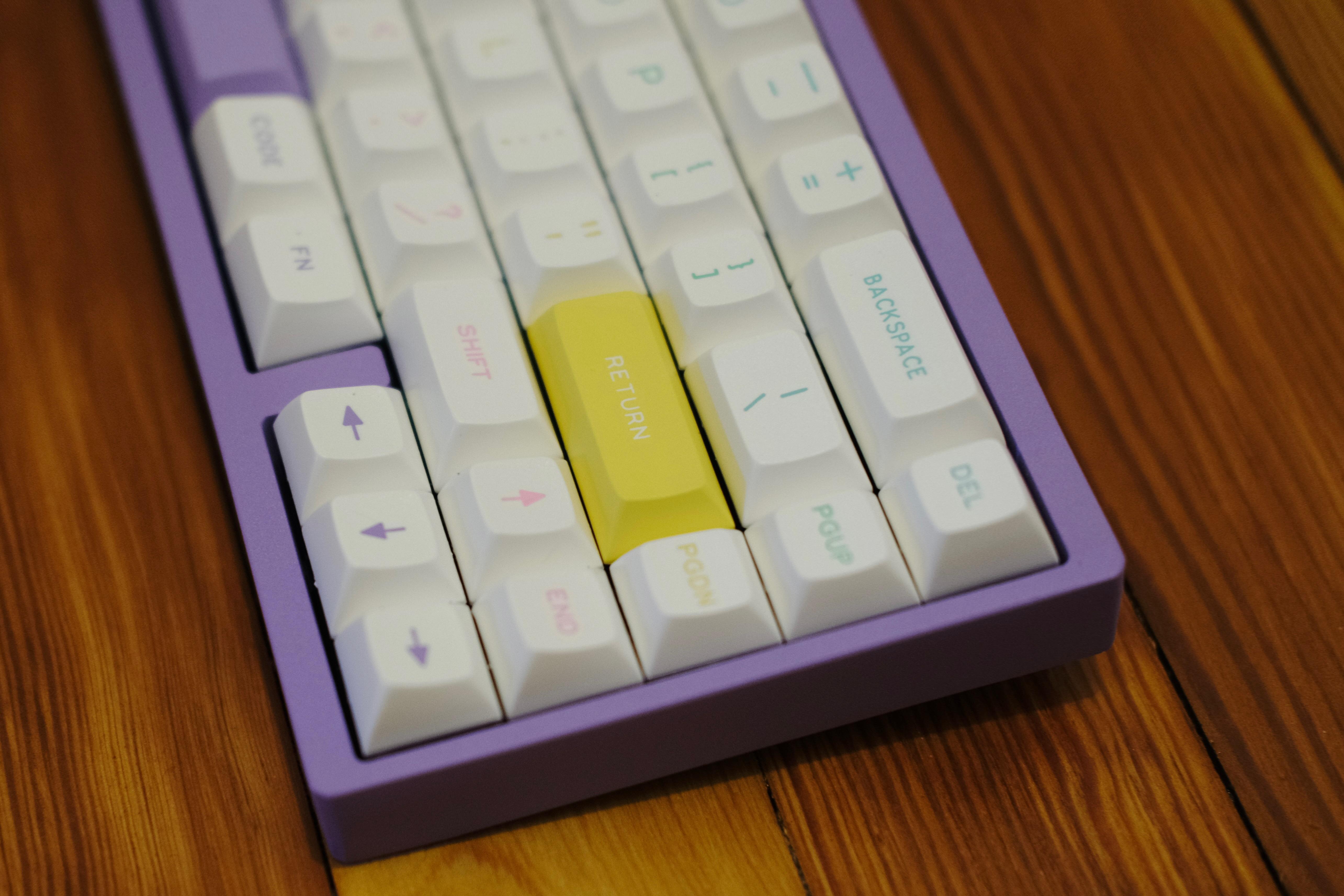 Closeup of the right-hand side of a keyboard, with a yellow return key in focus.