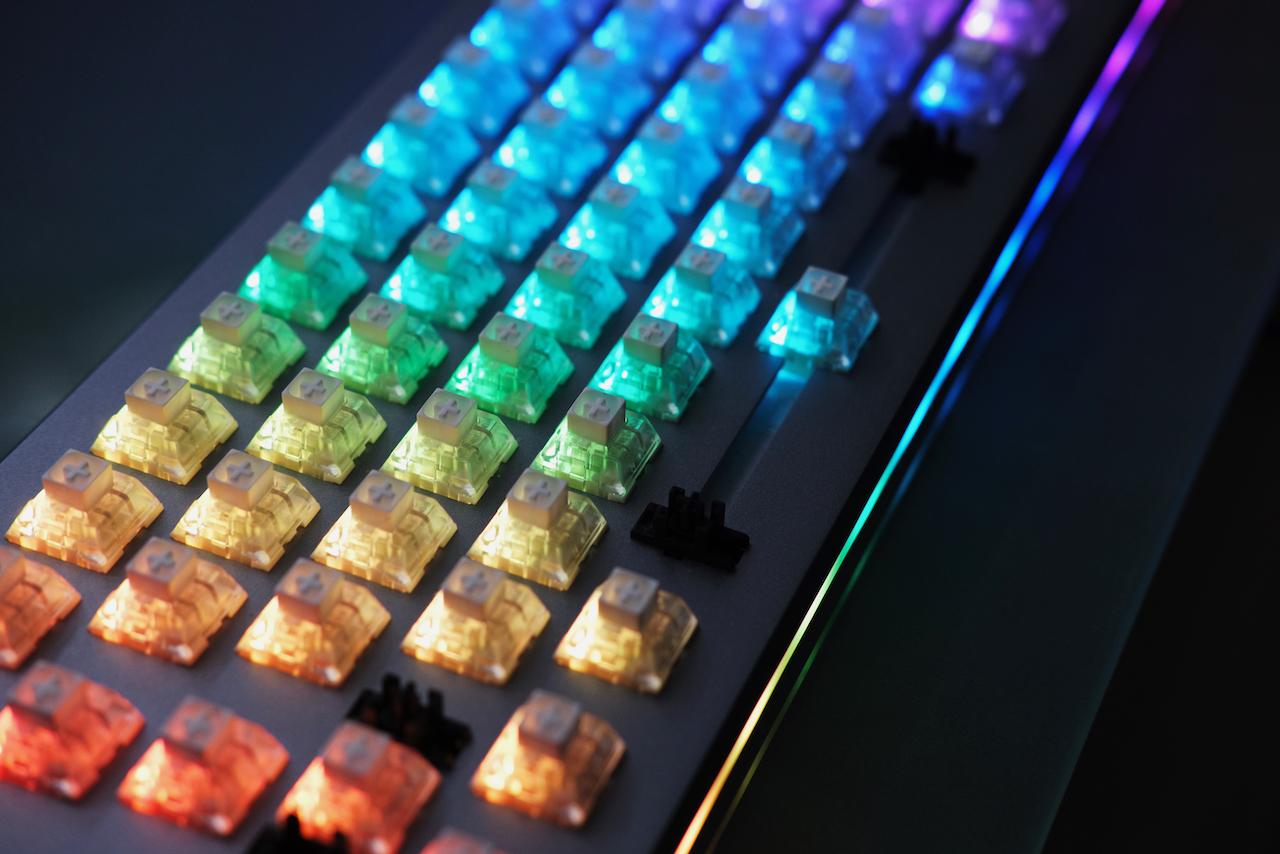 Keyboard with no keycaps and rainbow LEDs lit up.