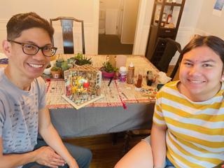 A father and daughter smile in front of their completed model.