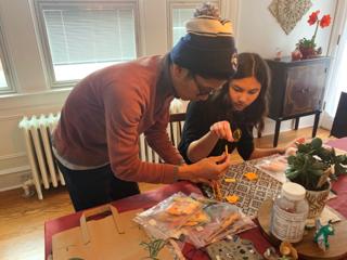 A father and daughter put together miniature furniture from a kit.