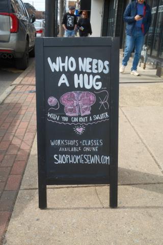 A chalk sidewalk sign for a knitting store.