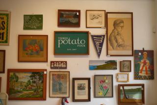 A wall with an arrangement of framed pictures and photos.