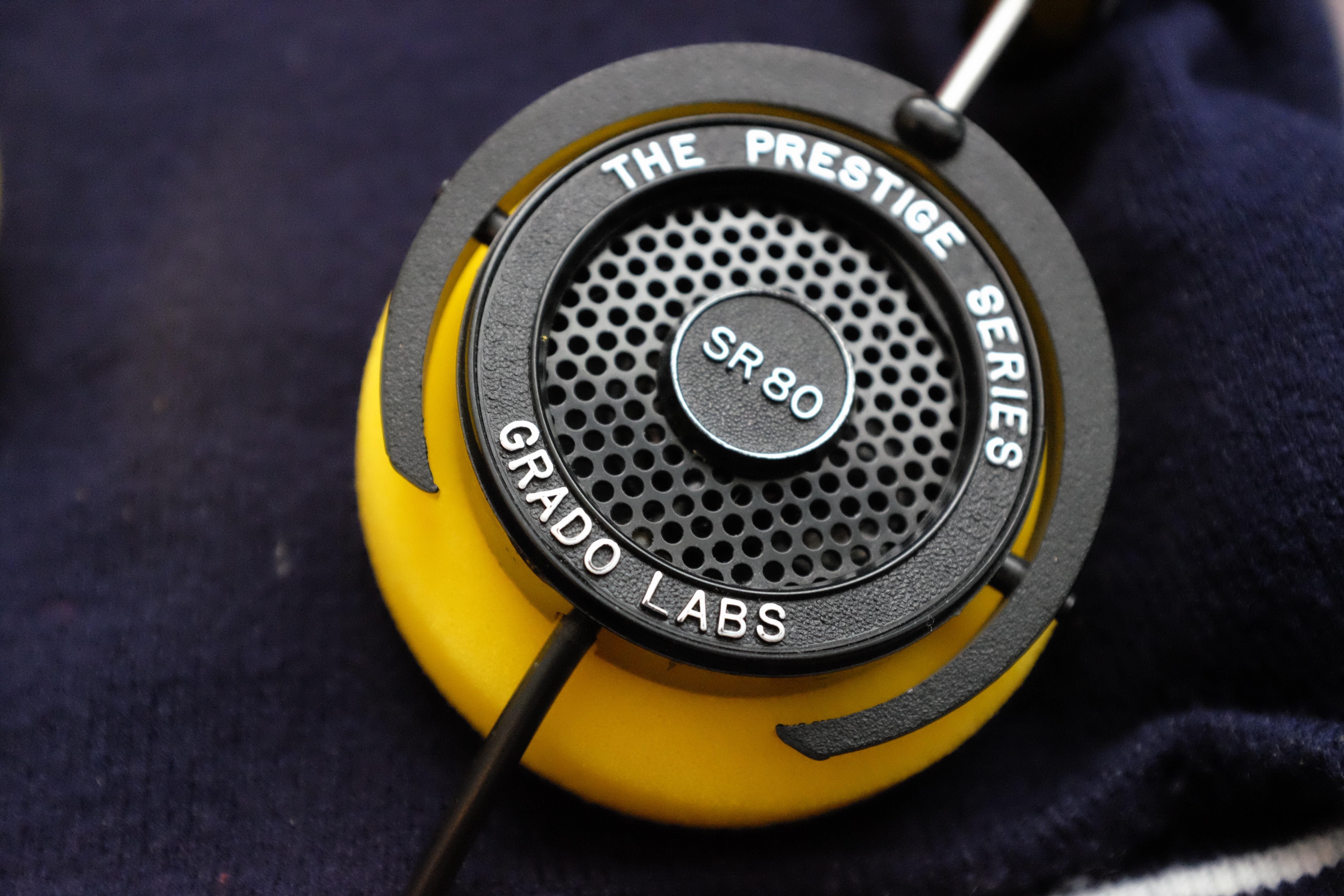 Closeup of a Grado SR-80 headphone earcup, with yellow foam earpad