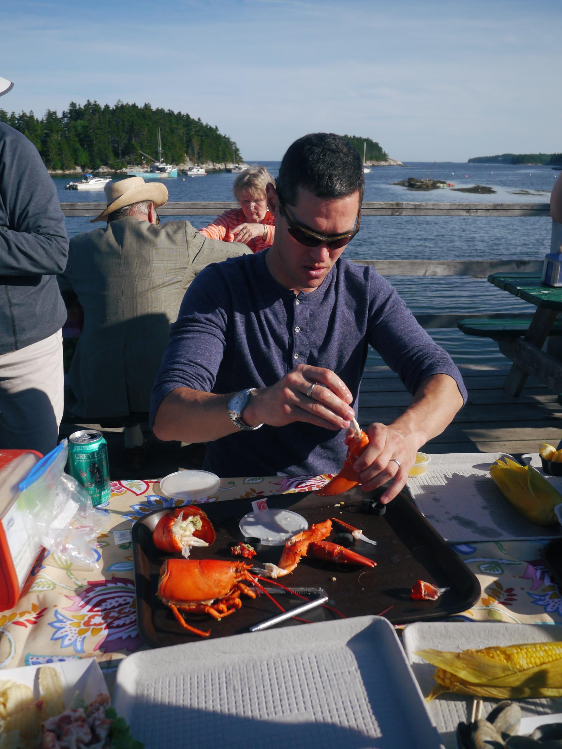 Man cracking a lobster for a young girl.