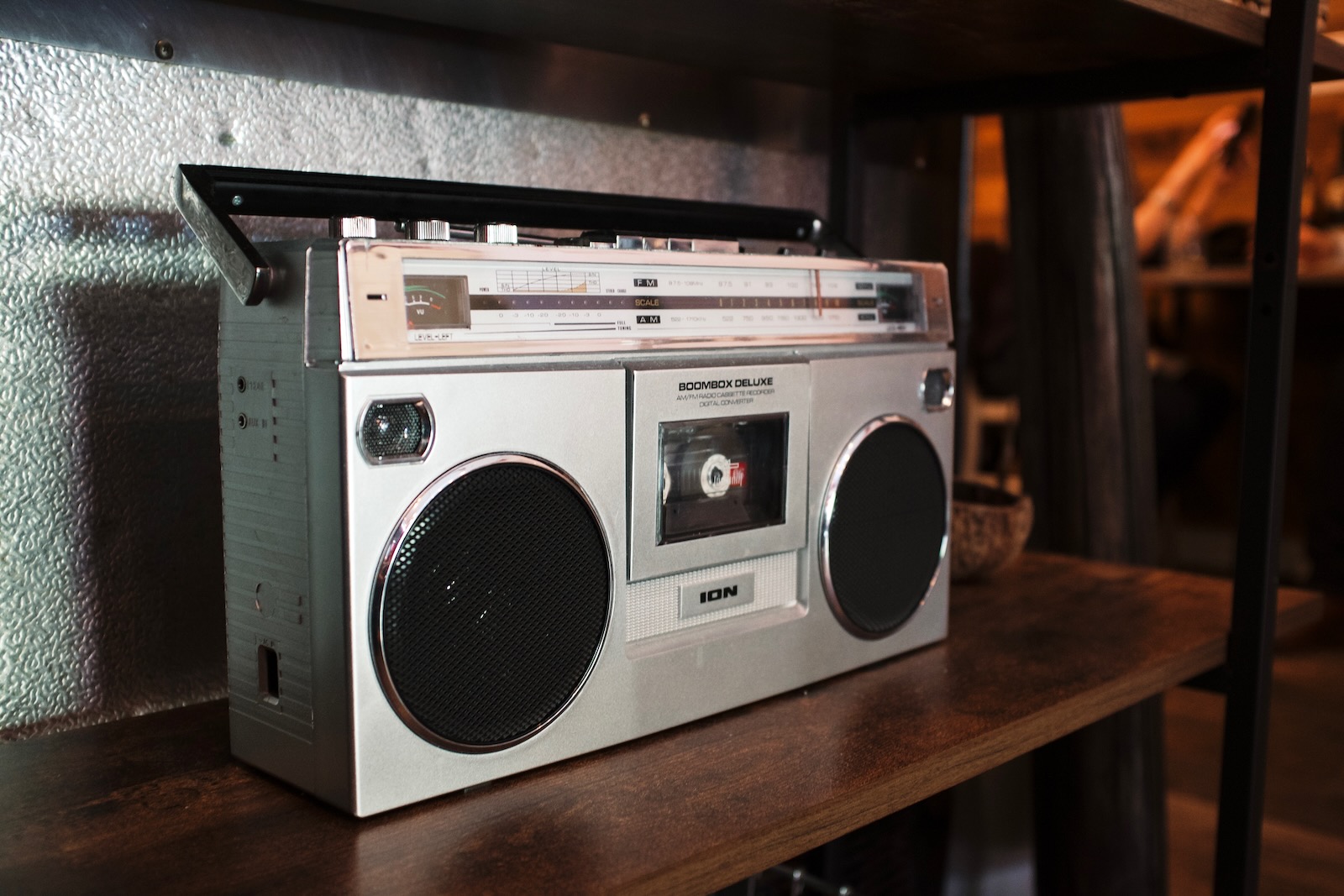 A silver boombox with a single cassette deck and a rotary radio tuner.