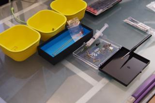 Disassembled keyboard stabilizers and a syringe full of lubricant, awaiting assembly.