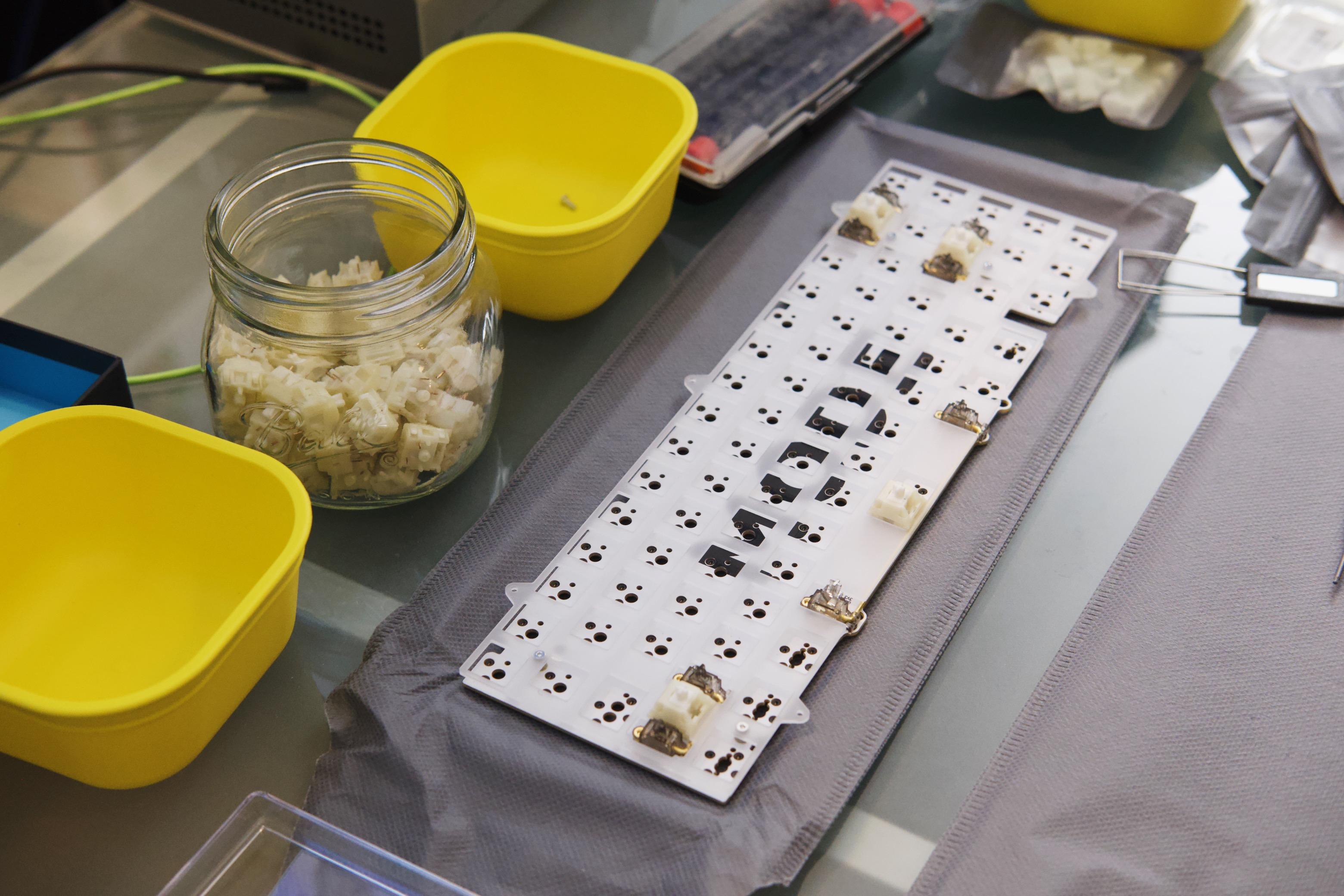 Polycarbonate plate seated over a keyboard PCB. Switches are mounted at the stabilizers for tuning.