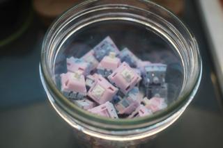 Keyboard switches with pink and blue housings in a mason jar.