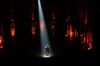 A single spotlight shines on Leslie Odom, Jr., playing Aaron Burr in “Hamilton”