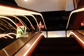 Neon-lit escalator leading to the second floor of the Tin Building.