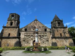 A Catholic church from the 1700s. In the center of a small rotunda in front is a statue of Christ atop a pillar.