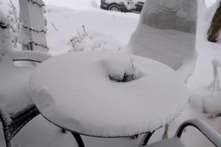 Outdoor table with inches of snow built up.