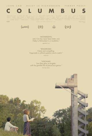 A man and a woman look into the distance at a concrete tower with an external staircase.