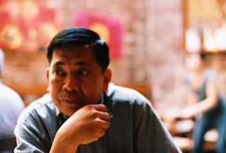 Close-up of a man in a restaurant, looking off to the right.