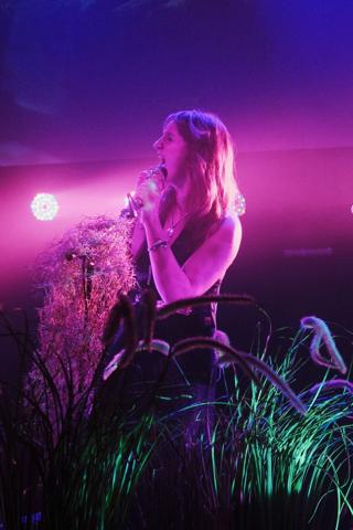 A singer, eyes closed, belts into the microphone.