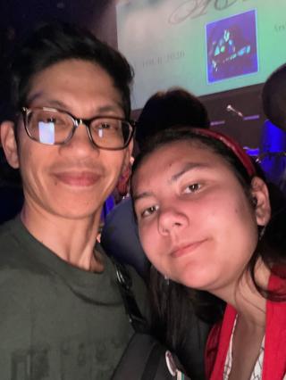 A father and child selfie in front of a projection backdrop.