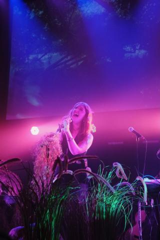 A singer, eyes closed, belts into the microphone.