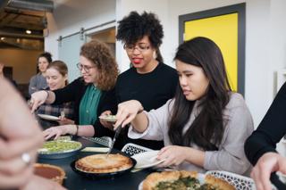 Smiling folks cutting into various pies.