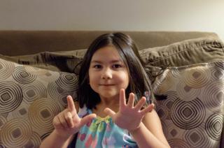 Amelia holding up seven fingers.